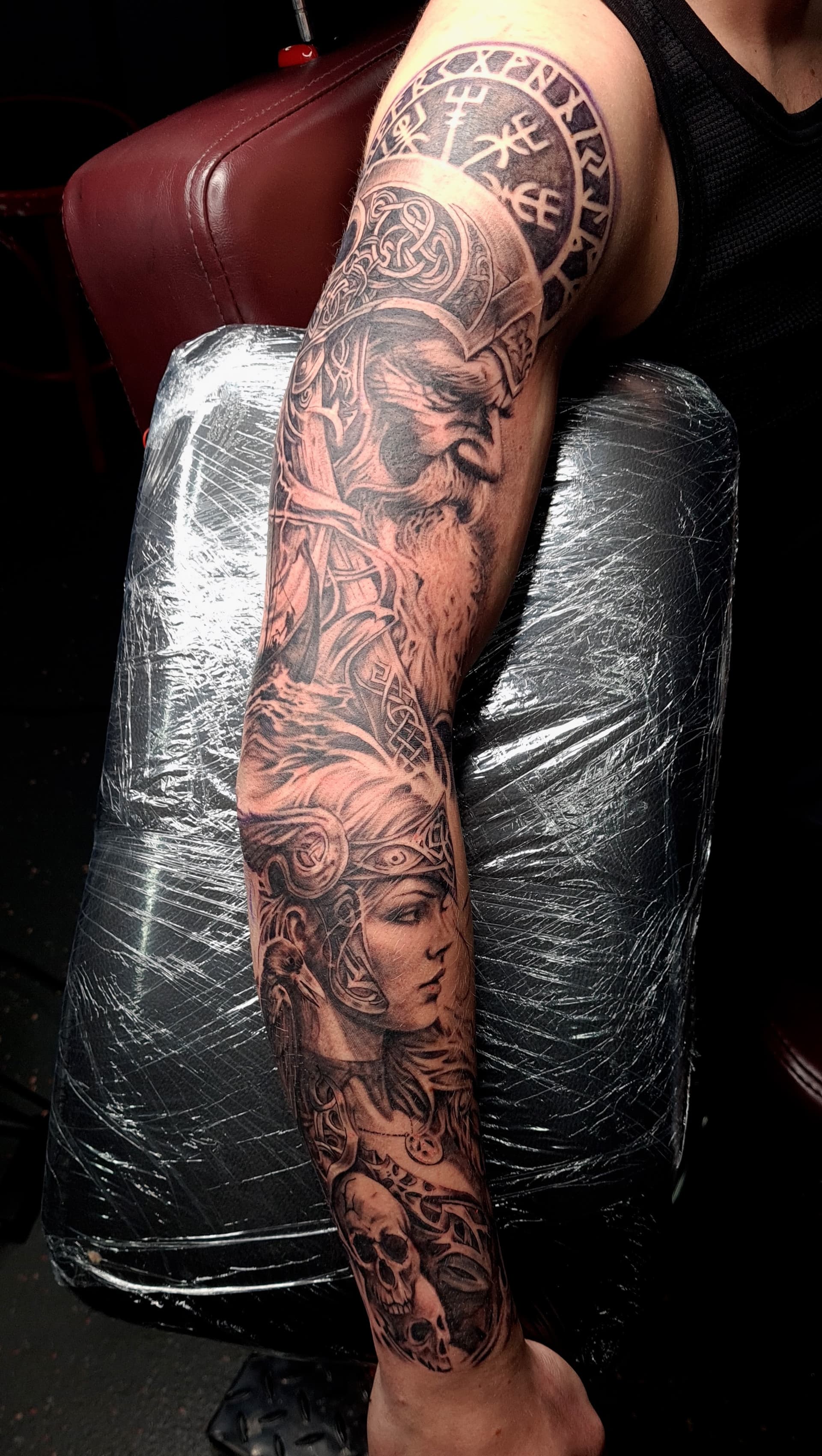 Detailed black grey realism tattoo featuring Norse deities on arm.