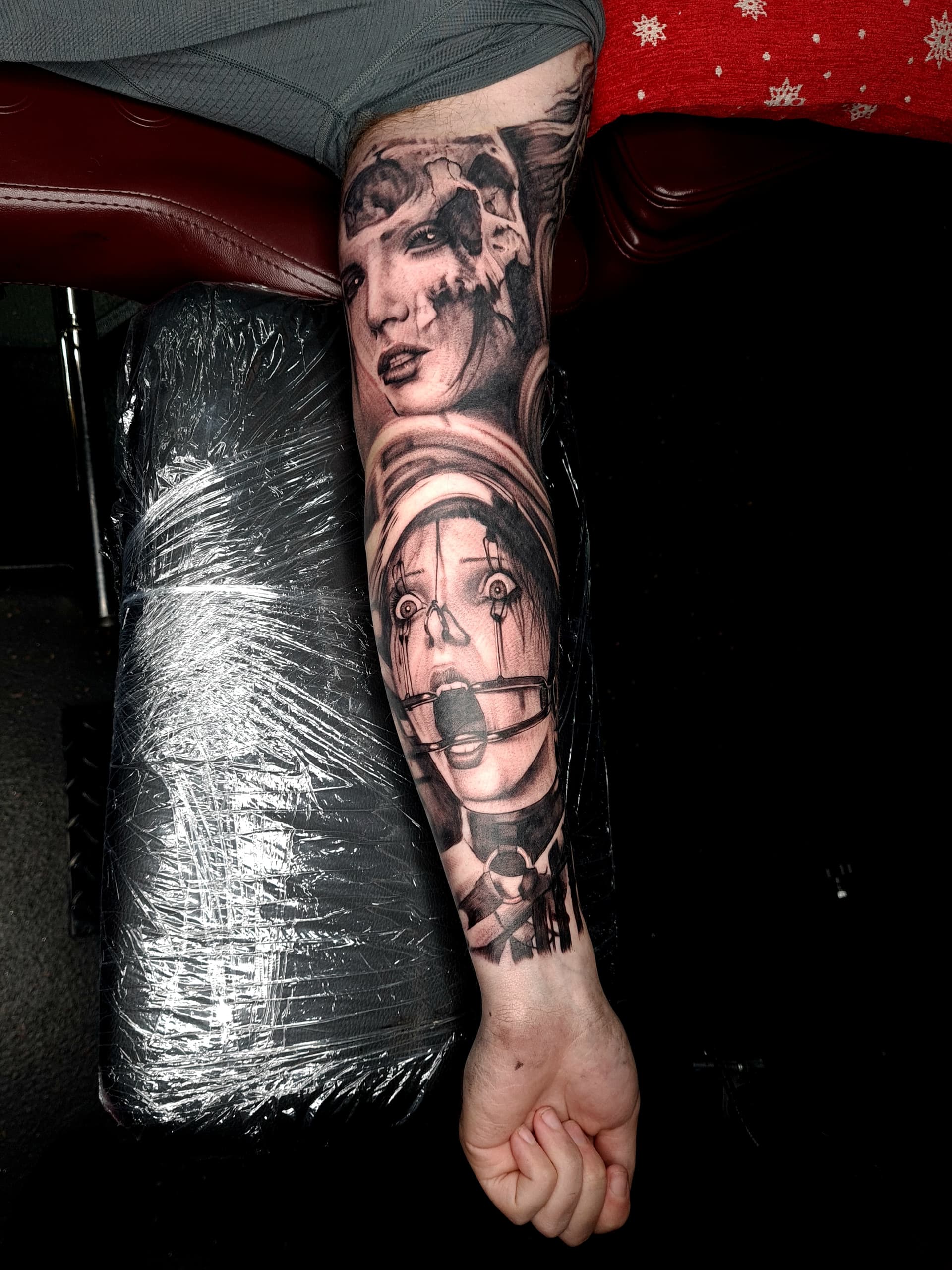 Detailed black and grey realism tattoo depicting two portraits on arm sleeve.