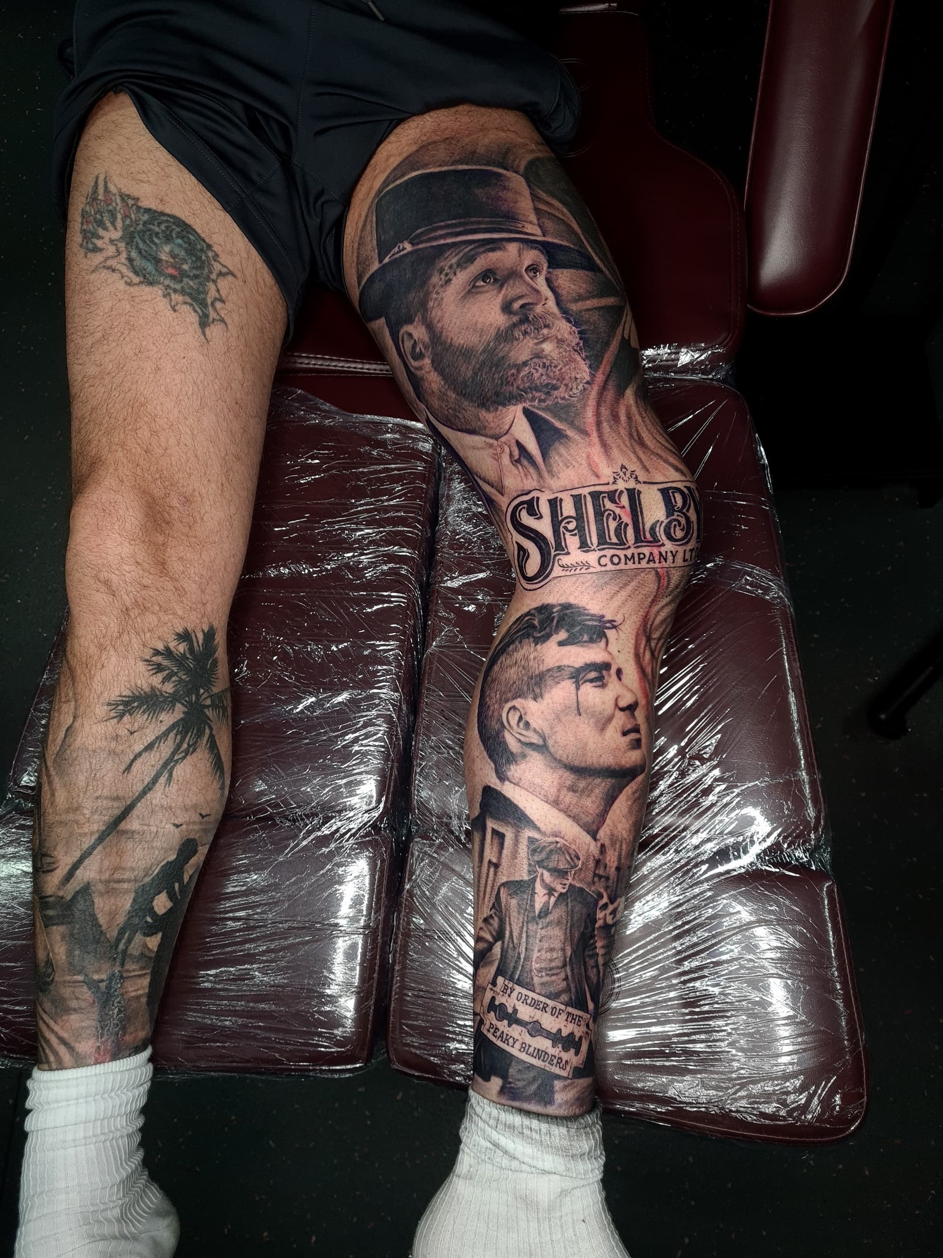 Detailed black and grey realism leg sleeve featuring peaky blinders characters.