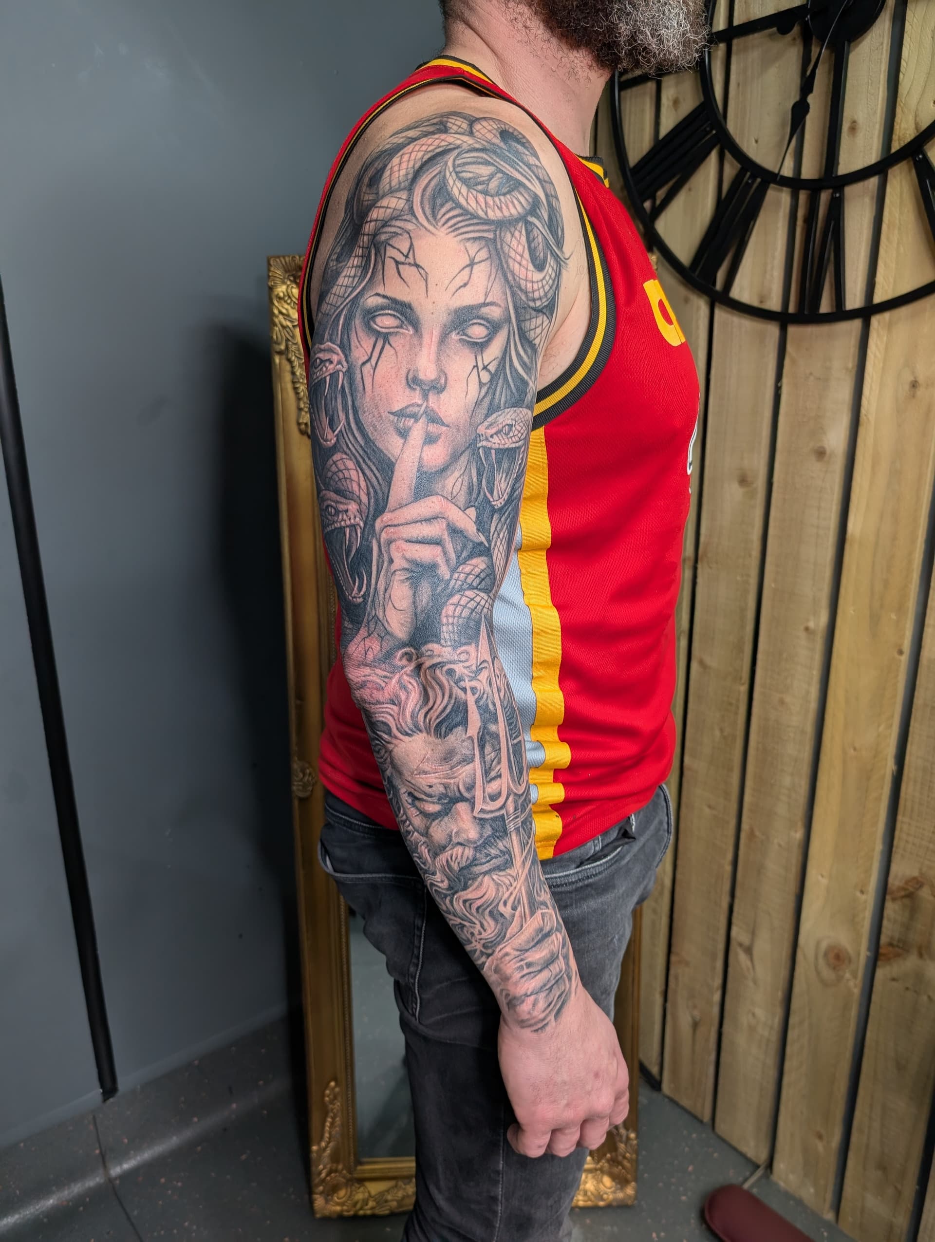 Detailed black and grey realism tattoo of Medusa and a warrior on arm.